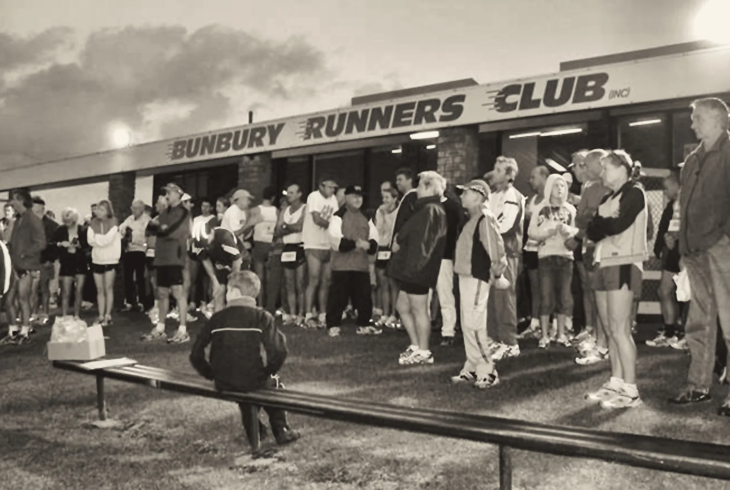 A crowd of runners and families gathered outside the Bunbury Runners Club building before a race.
